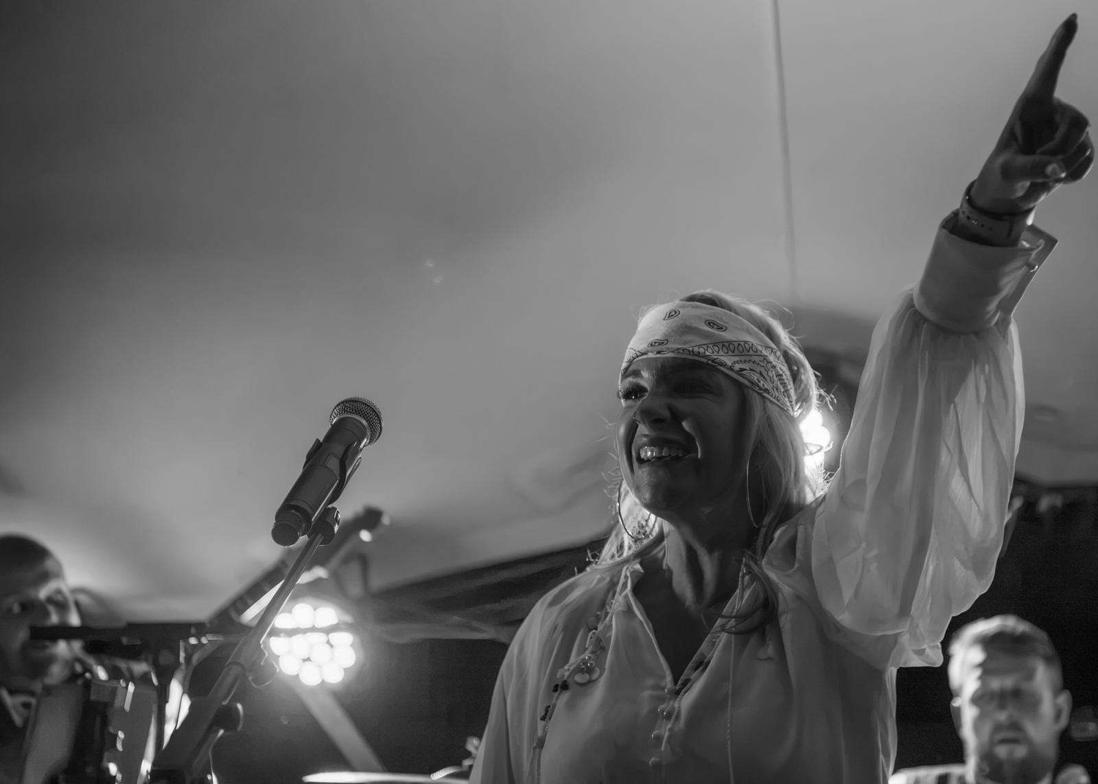 A singer pointing to the sky mid-chorus